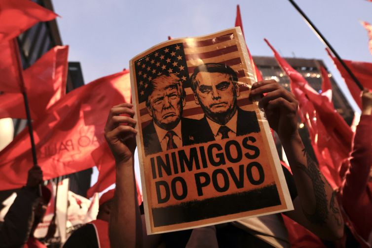 Paulo Pinto/Agência Brasil São Paulo (SP), 10/07/2025 - Cartaz com a foto do presidente Donald Trump e o ex-presidente Jair Bolsonaro, durante protesto à atuação do Congresso Nacional na justiça tributária com a taxação dos super ricos, fim da escala 6×1 e a isenção de Imposto de Renda para quem ganha até R$ 5 mil, realizado em frente ao MASP. Foto: Paulo Pinto/Agência Brasil