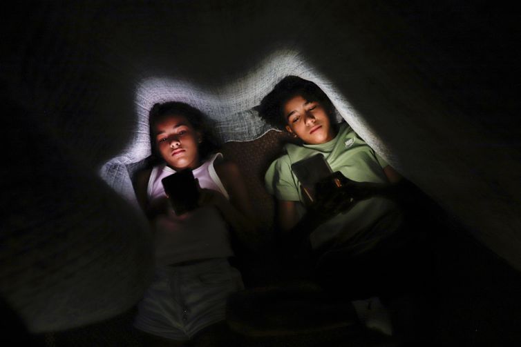 Brasília (DF) 28/01/2025 - Os irmãos Clara Santana (10) e Pedro Santana (13), são vistos com celular na mão embaixo de um cobertor.
Uma a cada 3 crianças tem perfil aberto em redes, alerta pesquisa
Dados foram divulgados nesta terça pela Unico e Instituto Locomotiva
Foto: Joédson Alves/Agência Brasil